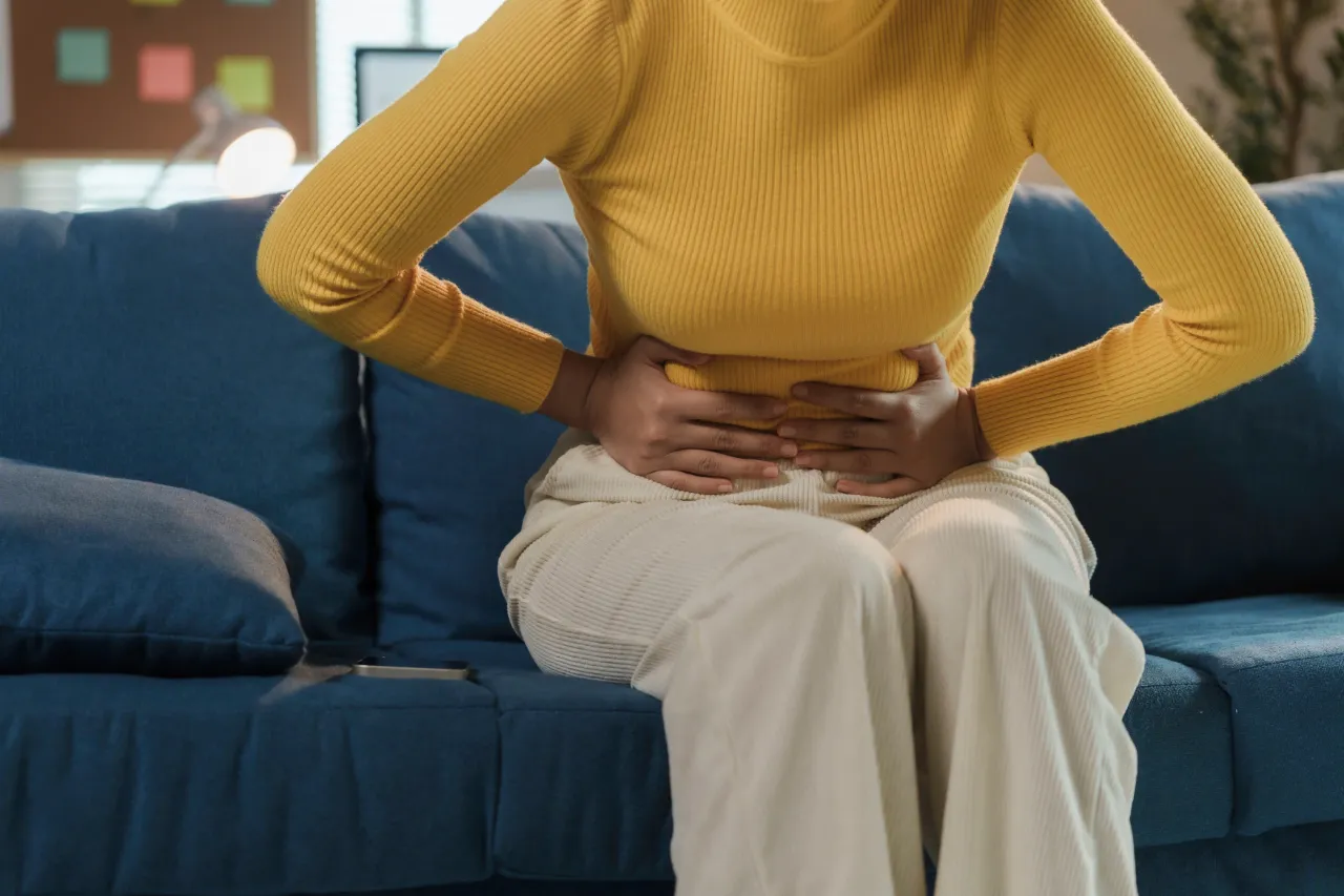 Woman experiencing pelvic pain caused by uterine fibroids.